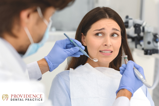 Nervous dental patient feeling anxious during a dental check-up with a dentist for nervous patients providing gentle care
